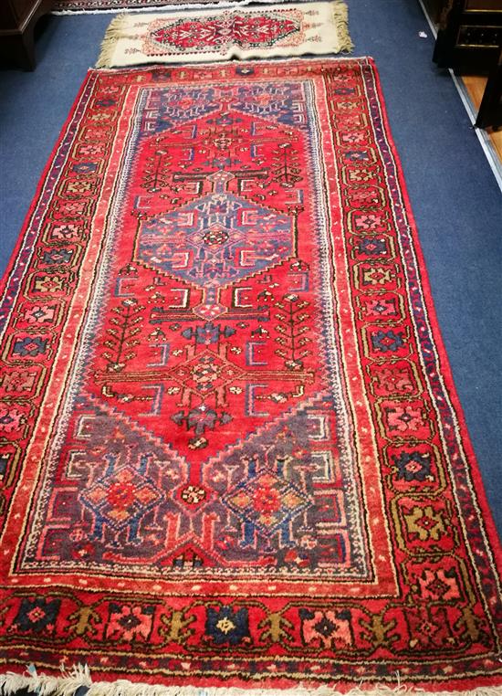 A Caucasian design red ground rug and a mat 186 x 100cm and 90 x 49cm
